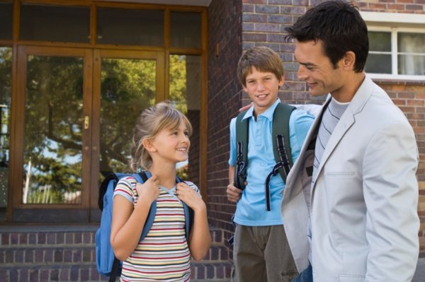 Padre con sus hijos en la puerta del colegio