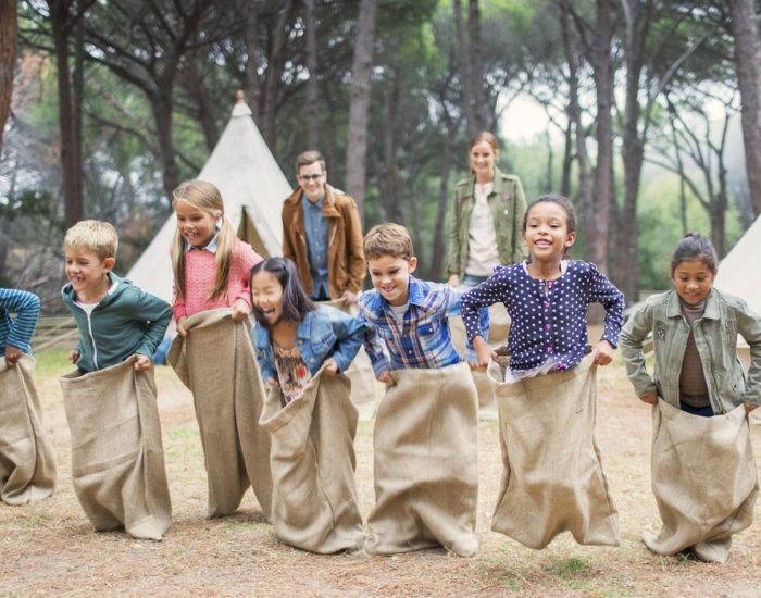 Children having sack race at campsite